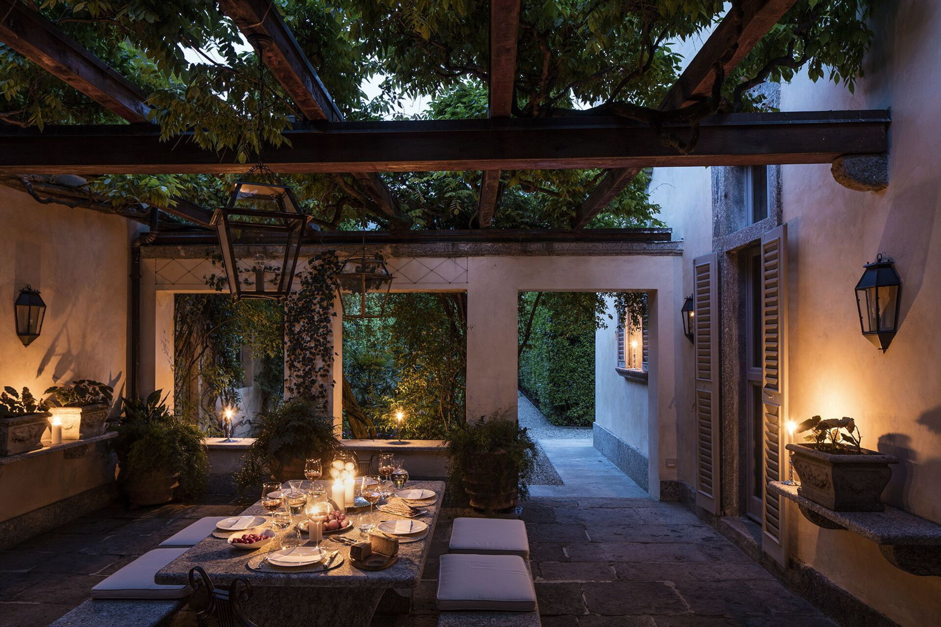 Villa Balbiano inner courtyard with wisteria pergola and candlelit dinner table