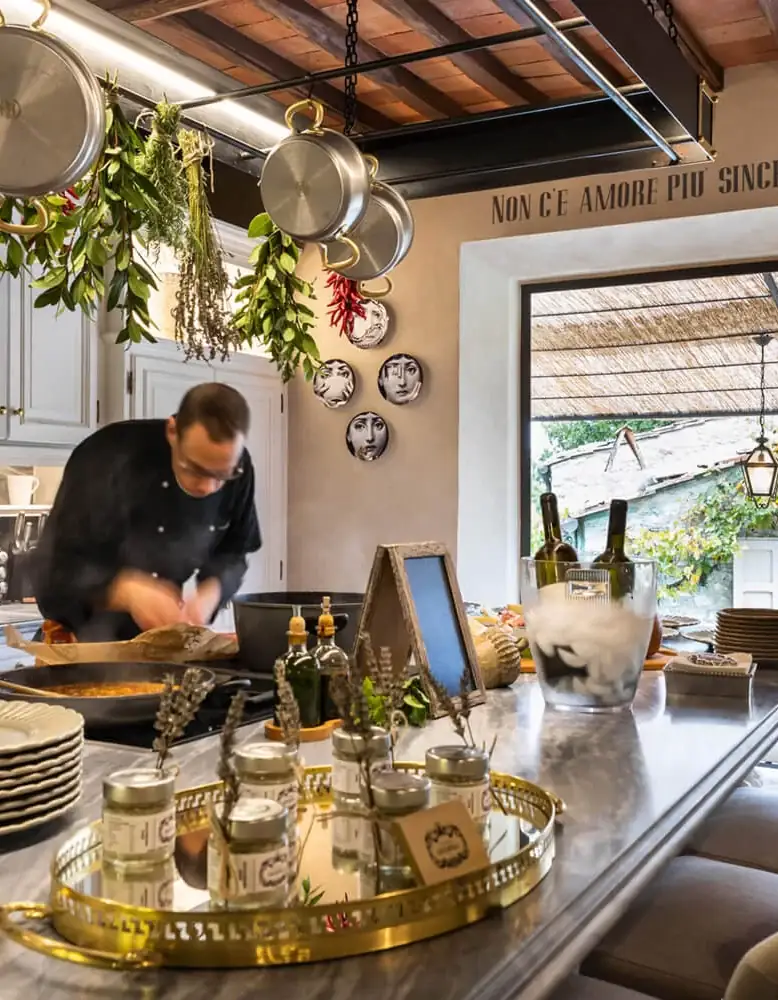 Private chef preparing a Tuscan tasting menu in a fresco-walled villa kitchen