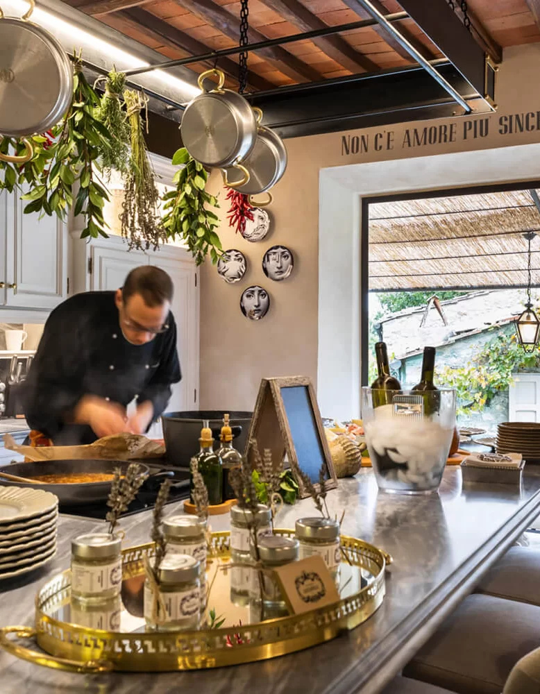 Private chef preparing a Tuscan tasting menu in a fresco-walled villa kitchen