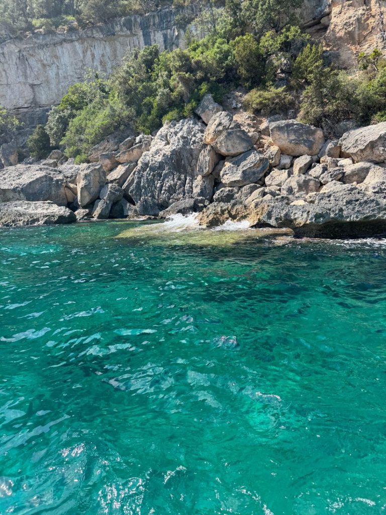 Crystal-clear turquoise water below the cliffs of the Gulf of Orosei