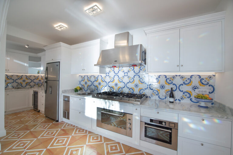 Villa Nuea — Kitchen with marble island and white cabinetry